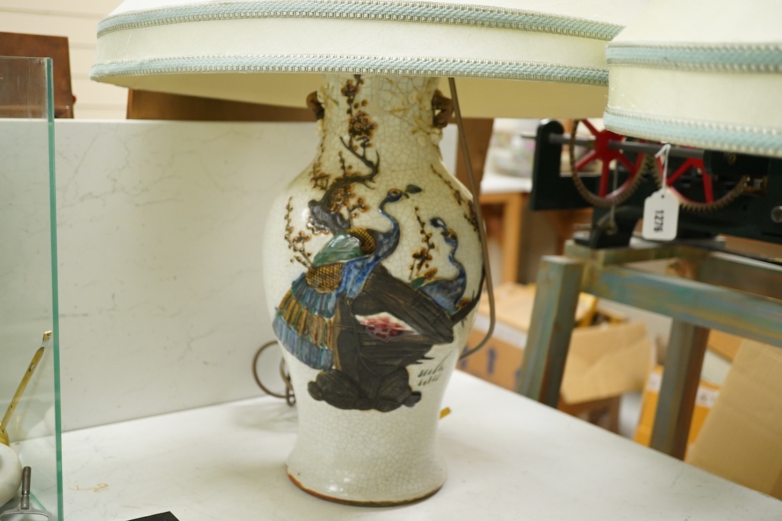 A large pair of early 20th century Chinese crackle glaze vases, mounted as table lamps, eac decorated in relief with peacocks, overall 80cm high